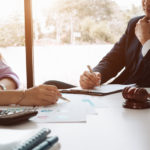 Image of a business man supervising and secretary executing business plan. Consultant analyzing company annual financial report balance sheet statement working with documents graphs; visualizes an audit and consultant.