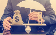 First Brands sues founder, alleges he faked invoices and siphoned off funds Businessman holding a white umbrella, protecting a dollar bag on basic balance scale, and defending money from being cheat or fraud.