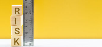 Risk assessment / risk analysis and management concept : Words RISK on wood blocks and a vertical ruler with scales, depict evaluation for financial risk of an investor involved in stock, bond market