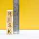 Risk assessment / risk analysis and management concept : Words RISK on wood blocks and a vertical ruler with scales, depict evaluation for financial risk of an investor involved in stock, bond market