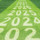 Years progressing from 2023 and on, painted on grass.
