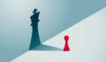 A red pawn chess piece with a shadow of a king chess piece