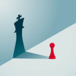 A red pawn chess piece with a shadow of a king chess piece