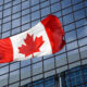 Canadian flag in front of modern building.