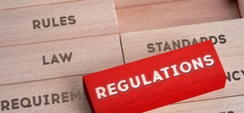 Wooden blocks with words written on them individually, representing the concept of regulations.