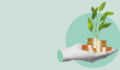 A severed hand holds several stacks of coins from which a green shoot sprouts