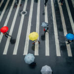 Group of people with umbrellas on the crosswalk, walking the street of Taipei on a rainy day.