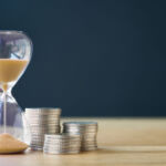 A brief history of (investment) time An hourglass next to a stack of coins