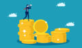 Image of a business person standing on a stack of coins.
