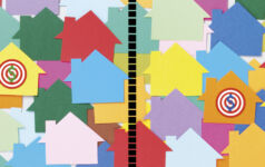 Illustrated photo of colorful houses laid over other houses, representing the real estate and housing sectors.