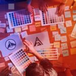 Do private markets require a rebrand? Marketing executives and graphic designers spread logo options and colour swatches over a table to decide on a rebrand