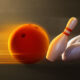 A bowling ball knocks over bowling pins