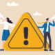 Two people holding a warning sign and both shouting into a megaphone