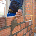 Real estate brokers turn to private credit funds โ report Worker building masonry house wall with bricks