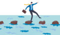 A businessman walks across stepping stones on water
