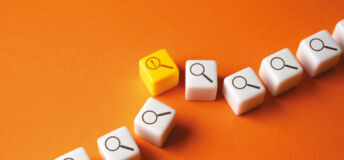 White cubes with a magnifying glass icon are lined up, with one yellow one bumped slightly out of line