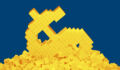 A dollar sign compromised of lego bricks collapses and sinks into a pile of lego bricks