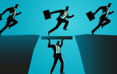Medallia taken over by Blackstone-led creditor group A businessman holds up a plank between two cliffs so other businessman can run over it