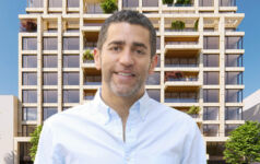 Martin Nussbaum, co-founder and principal at Slate Property Group, in front of a rendering of 264-272 West 135th Street in the Harlem neighborhood of Manhattan.