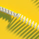 A line of dominoes begins to cascade over a yello floor
