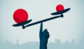 Image of a hand balancing red balls on a scale.