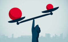 Image of a hand balancing red balls on a scale.