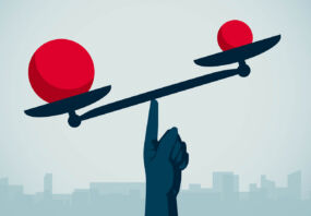 Image of a hand balancing red balls on a scale.